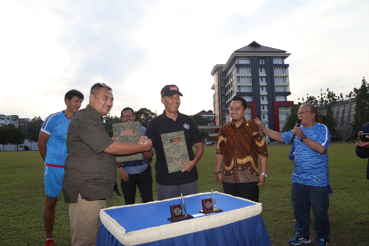 Rektor UMM Fauzan (bertopi) dan Direktur Arema Rudy Widodo berjabat tangan usai menandatangani MoU.